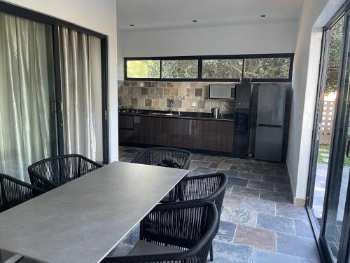a kitchen with a table and chairs and a refrigerator at Massala Beach Resort, Lda in Vila Praia Do Bilene