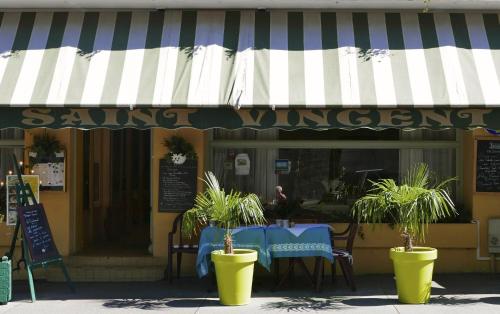 a restaurant with a table with plants in front of it at Hôtel Saint Vincent in Bagnères-de-Bigorre