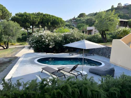 una piscina con due sedie e un ombrellone di Villa Giacinti a Lingua