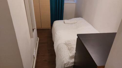 een kleine kamer met een bed en een televisie bij Bethnal Green Guest House in Londen
