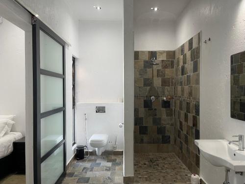uma casa de banho com um lavatório, um WC e um chuveiro em Massala Beach Resort, Lda em Vila Praia do Bilene