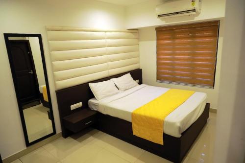 a small bedroom with a bed and a mirror at GRANDE IVORY INN in Kalpetta
