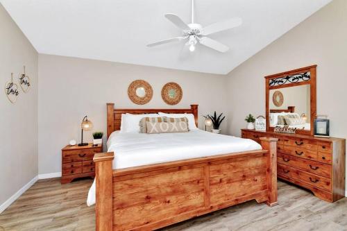 a bedroom with a wooden bed and a ceiling fan at Lakeview Luxury Oasis in Kissimmee