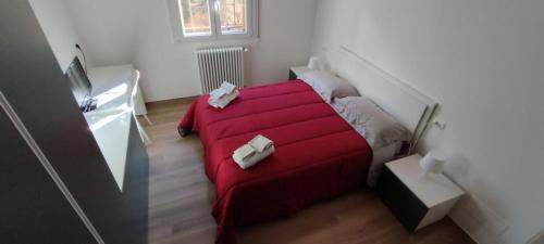 a bedroom with a red bed in a room at BOLOESTHOUSE in Bologna