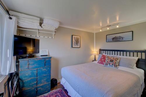 um quarto com uma cama e uma cómoda com uma televisão em Akari Bungalow #5 em Long Beach
