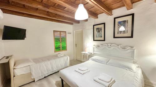 een slaapkamer met een wit bed en een televisie bij Davanzati Boutique Apartment in Florence