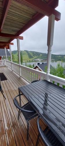 a wooden deck with a bench on a porch at Hallan Alpit A mökki in Hyrynsalmi