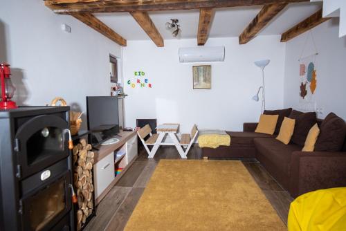 a living room with a couch and a tv at Ház a szígeten in Fonyód