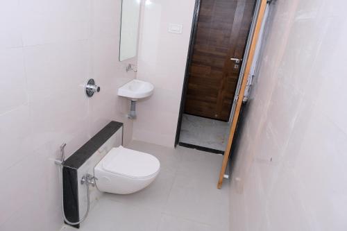 HOTEL SAYALI في Bhusāwal: حمام صغير مع مرحاض ومغسلة