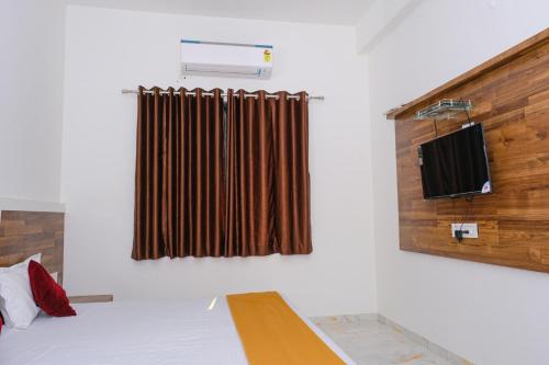 HOTEL SAYALI في Bhusāwal: غرفة بسرير ونافذة مع ستارة