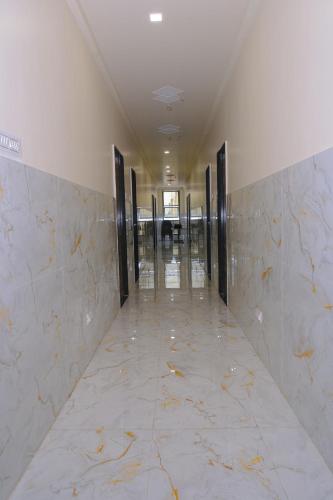 HOTEL SAYALI في Bhusāwal: ممر فارغ في مبنى به جدران من الرخام