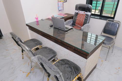 HOTEL SAYALI في Bhusāwal: مكتب به مكتب وبه لاب توب وكراسي