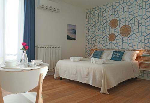 a bedroom with a white bed and a table and a wall at Casa D'Antò in Petralia Sottana
