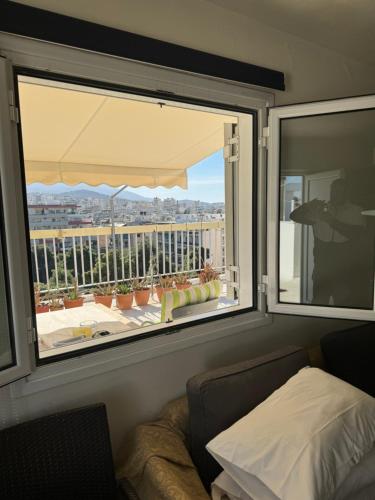 - une chambre avec une fenêtre donnant sur un balcon dans l'établissement George, à Athènes