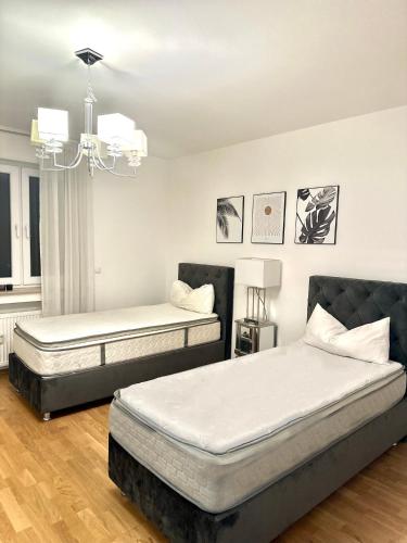a bedroom with two beds and a chandelier at FMI Apartmets next to Frankfurt Airport in Frankfurt/Main