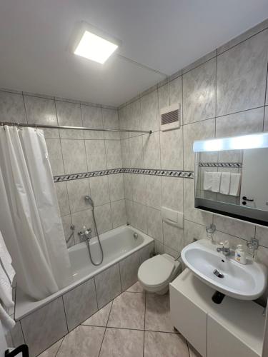 y baño con aseo, bañera y lavamanos. en Lungolago Blu Sky, en Locarno