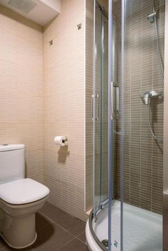 a bathroom with a toilet and a glass shower at Valle de Sueños in Escarrilla