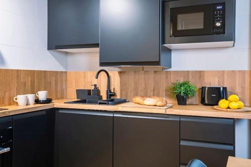 a kitchen with a counter with a sink and a microwave at Valle de Sueños in Escarrilla