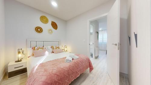 a white bedroom with a bed with a pink blanket at Kastrexana Apartamento con tranquilidad y wifi in Bilbao