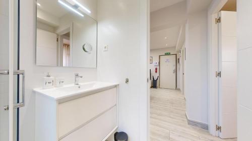 a white bathroom with a sink and a mirror at Kastrexana Apartamento con tranquilidad y wifi in Bilbao