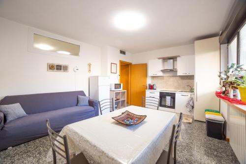 a living room with a table and a blue couch at Melannie's Apartment in Bergamo