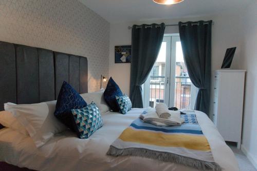 a bedroom with a large bed with blue and white pillows at Domus, With free secure parking on site in York
