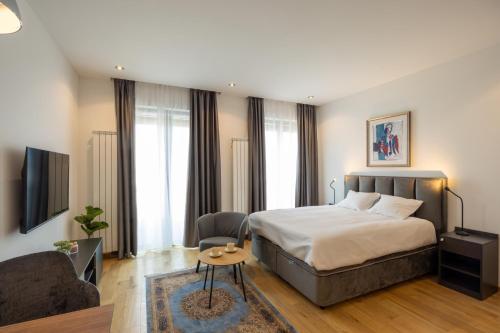 een slaapkamer met een bed, een bank en een stoel bij Belgrade Center Apartment Lux 1 in Belgrado