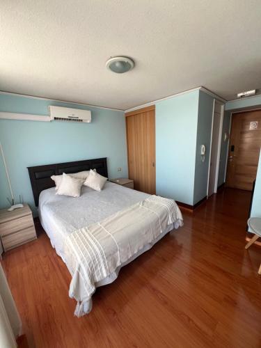 a bedroom with a bed and a wooden floor at Zenteno Apartments in Santiago