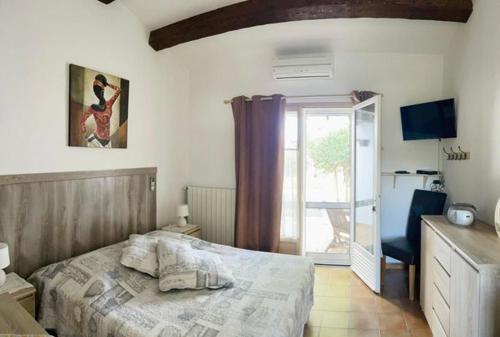 Schlafzimmer mit einem Bett und einer Glasschiebetür in der Unterkunft les deux pins in Saintes-Maries-de-la-Mer