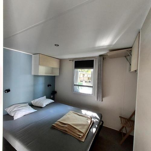 une petite chambre avec un lit et une fenêtre dans l'établissement Mobil home - N025, à Boofzheim