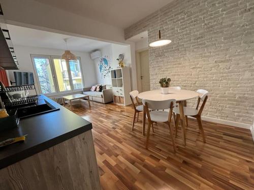 Una cocina y una sala de estar con una mesa y sillas blancas. en Family friendly downtown apart, en Sofía