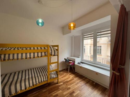 Un dormitorio con una litera y una ventana. en Family friendly downtown apart, en Sofía