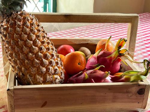 a wooden box filled with fruit and a pineapple at The Bungalow Bogmalo An 1880 Indo Portuguese Heritage Beach Villa South Goa in Bogmolo
