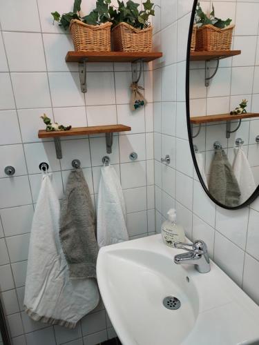 a bathroom with a sink and a mirror and towels at Marmorcafets B&B in Kolmården