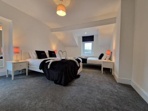 1 dormitorio con 2 camas y sofá en 5 Bedroom modern home with parking. Near Brecon Beacons & Bike Park Wales, en Merthyr Tydfil