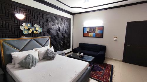 a bedroom with a bed and a chair in it at Aleph Islamabad Guest House in Islamabad