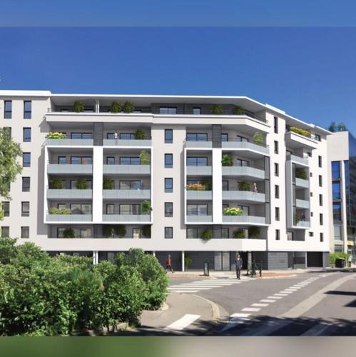 a white apartment building with a street in front of it at Villa du Centre in Annemasse