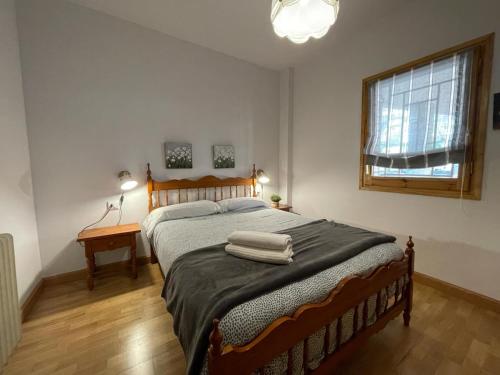 a bedroom with a large bed with two towels on it at Apartamento Capelot in Jaca