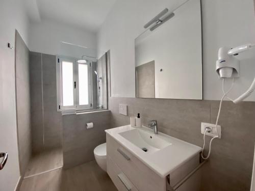 a white bathroom with a sink and a toilet at Casa Antonio - apartamento Orion in Playa de San Juan