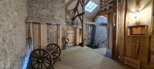 a hallway of a building with wooden walls and a wheel at La Cabane et SPA Chez Jules in Vellerot-lès-Vercel