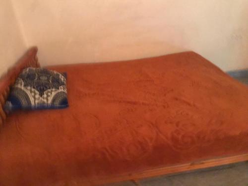 een bed met een rood laken en een kussen erop bij El houda beni mellal in Beni Mellal