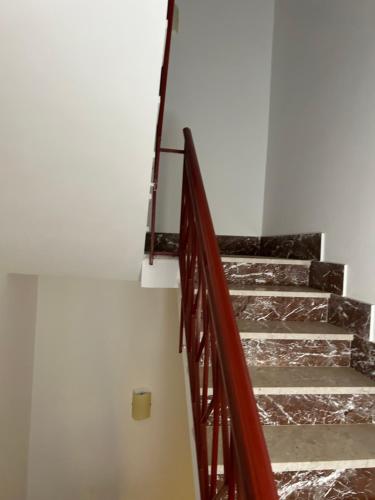 a set of stairs in a white room with metal railing at Gli Ulivi in Marinella di Selinunte