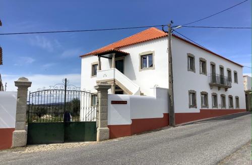 a white house with a red and white fence at Quinta da Mouracha in Águas