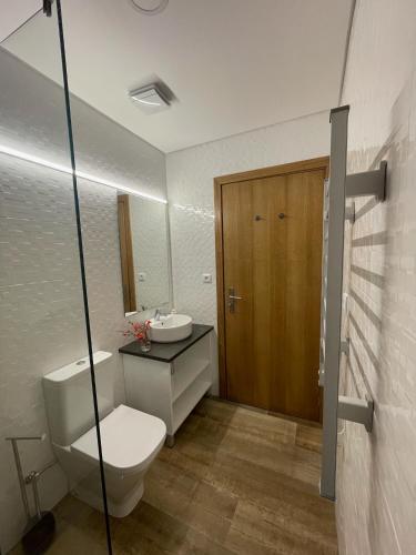 a bathroom with a toilet and a sink and a mirror at Quinta da Mouracha in Águas