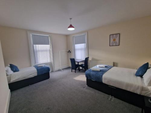 a room with two beds and a desk and a chair at LaLuNa One Bedroom Apartment Newcastle in Elswick