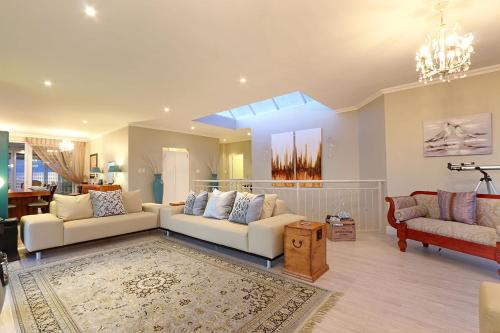 uma sala de estar com dois sofás brancos e um tapete em Bayview 30 by HostAgents em Bloubergstrand