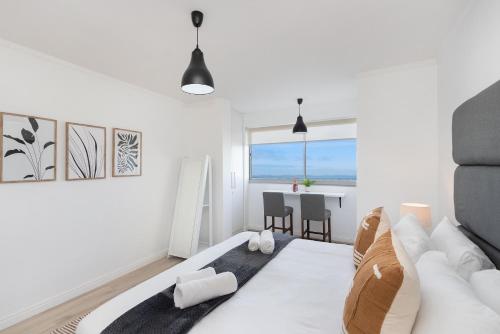 a white room with a couch and a table at Blouberg Heights 207 in Bloubergstrand