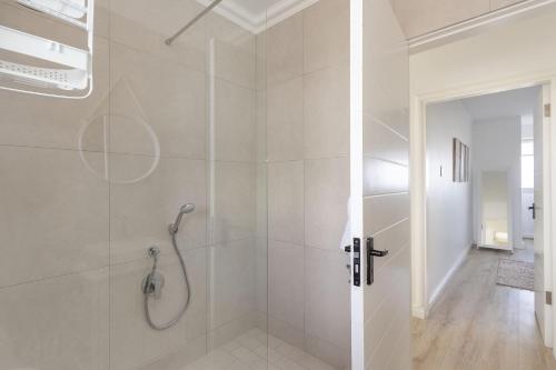 een badkamer met een douche en een glazen deur bij Blouberg Heights 207 in Bloubergstrand