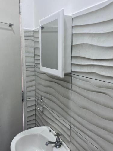 a bathroom with a sink and a mirror at Edículas da vivi in Sao Paulo
