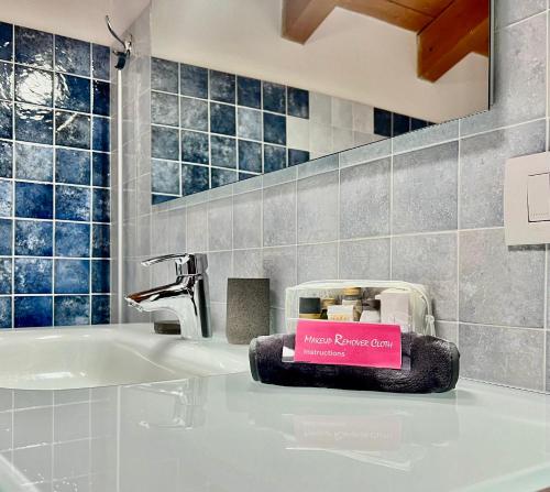 un lavandino in bagno con un cartello rosa di Sonhozinho House Colico a Colico